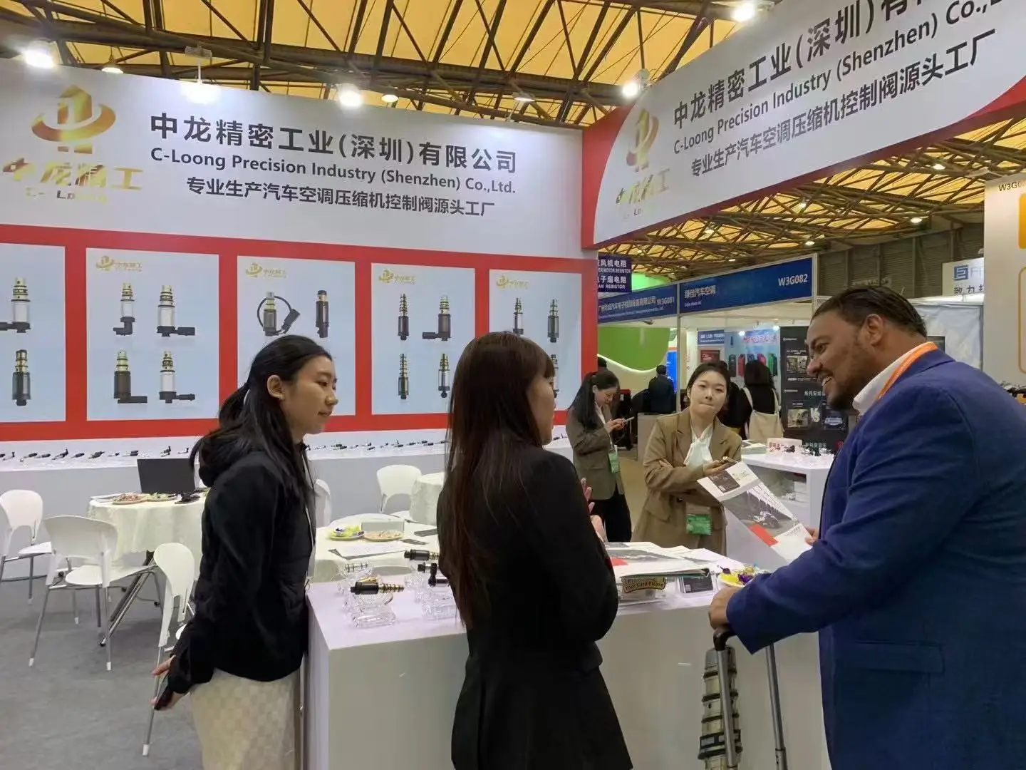 C-Loong sales team talking with a buyer at an automotive parts trade show booth